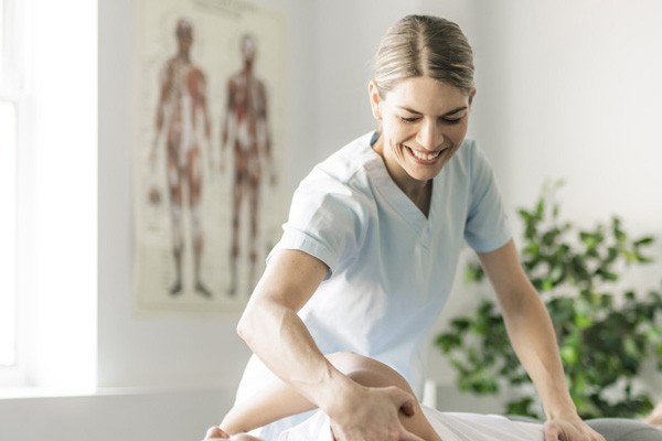 Female owner of chiropractic practice seeing patient 