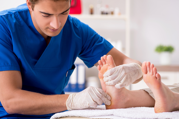 Podiatrist treating patient at clinic